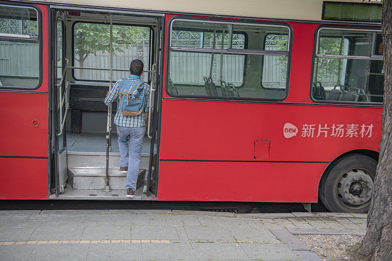 戴着耳机的年轻人正在上公交车