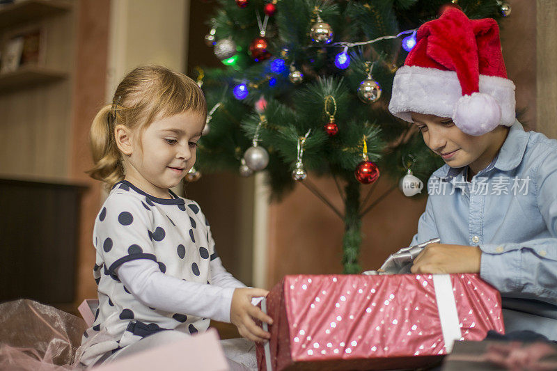 孩子们微笑着打开圣诞礼物