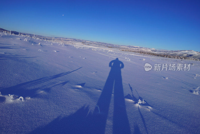 雪中的人的长长的影子