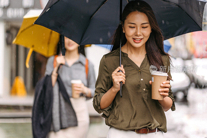下雨天带着伞走路的妇女