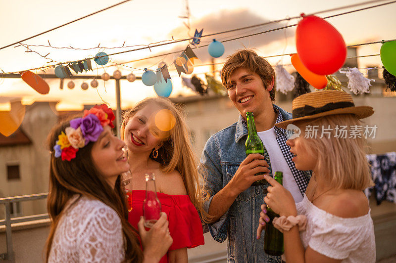 一群年轻人在一个屋顶聚会上玩日落