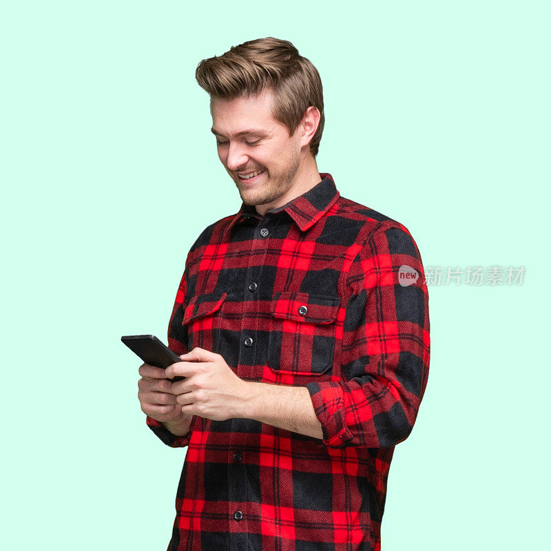 白人年轻男性穿着伐木工人衬衫，用手机