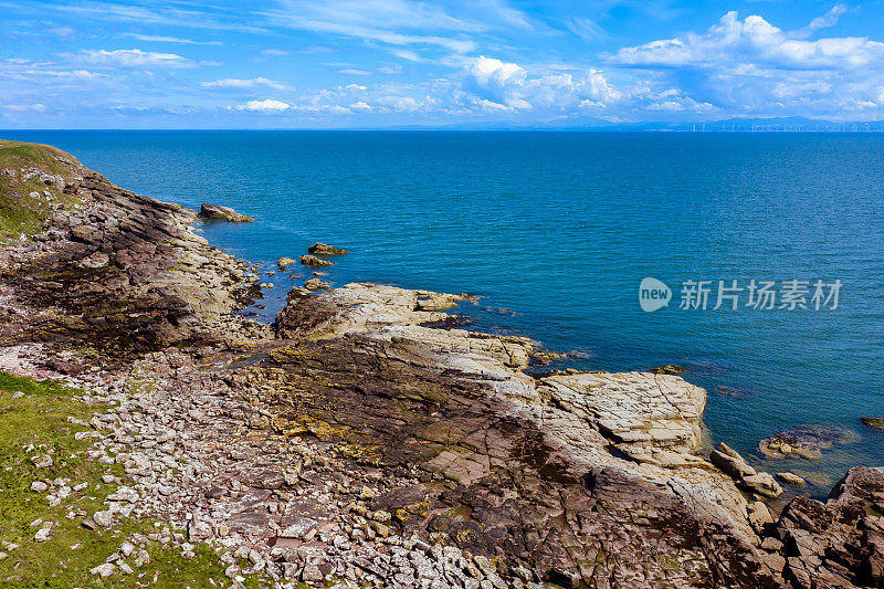 高角度的崎岖的岩石海岸和海在邓弗里斯和加洛韦，苏格兰西南部。这张照片是由一架无人机在一个阳光明媚的夏日午后拍摄的。