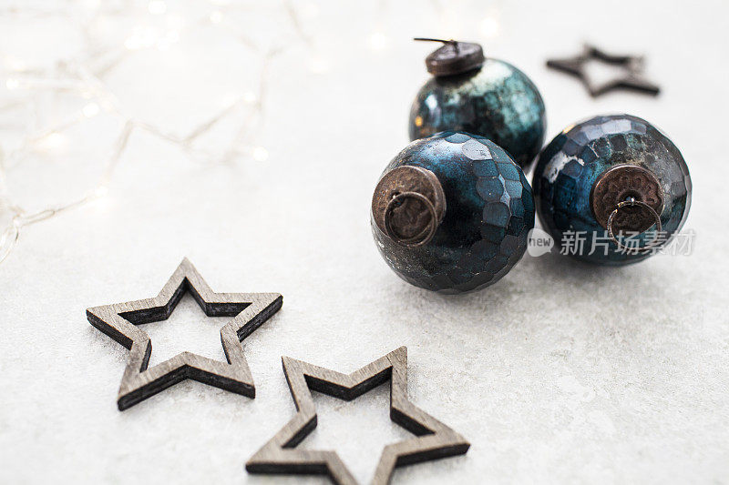 复古的蓝色圣诞装饰物，木质星星和细绳灯在轻盈的纹理表面上
