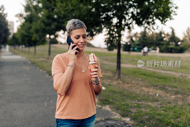 一个边走边吃冰淇淋边打电话的漂亮女人