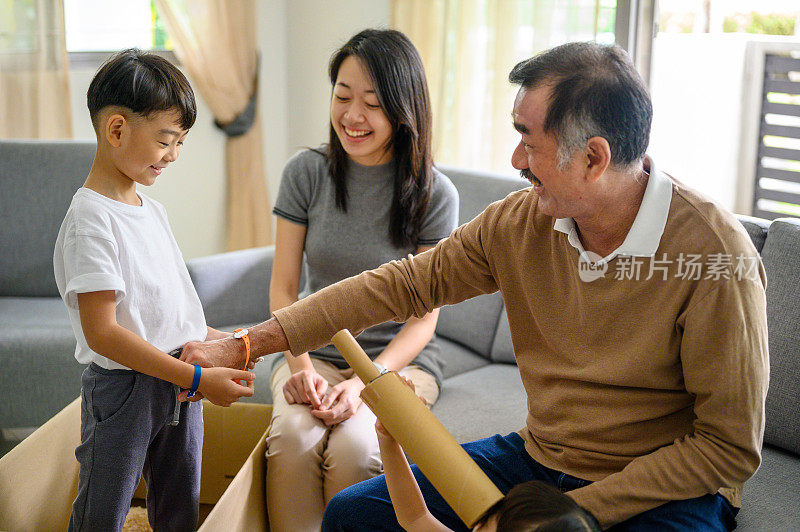 一个亚洲男孩帮祖父戴腕带