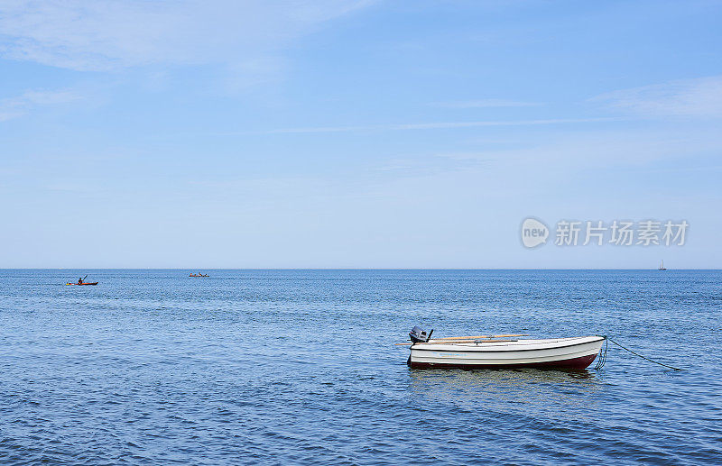 一只小船停泊在海岸附近的海里