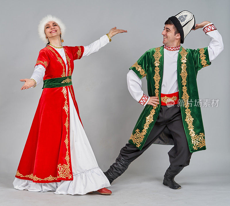 两个欢快的舞者(男和女)穿着民族传统服装正在跳吉尔吉斯舞