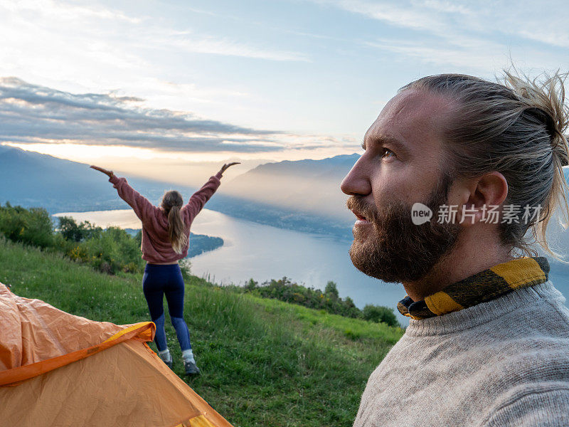 一对夫妇在山顶露营，日出