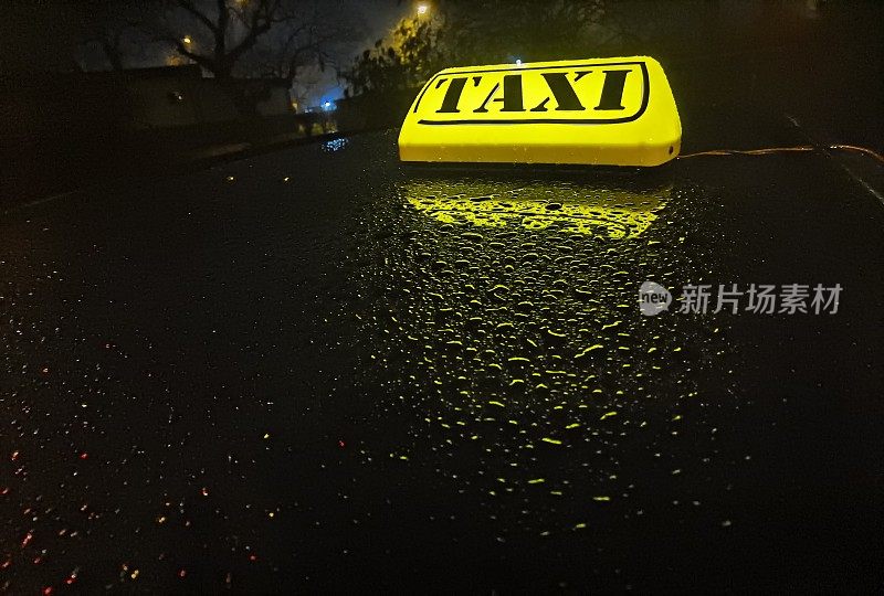 车顶的出租车灯点亮了，周围是雨滴