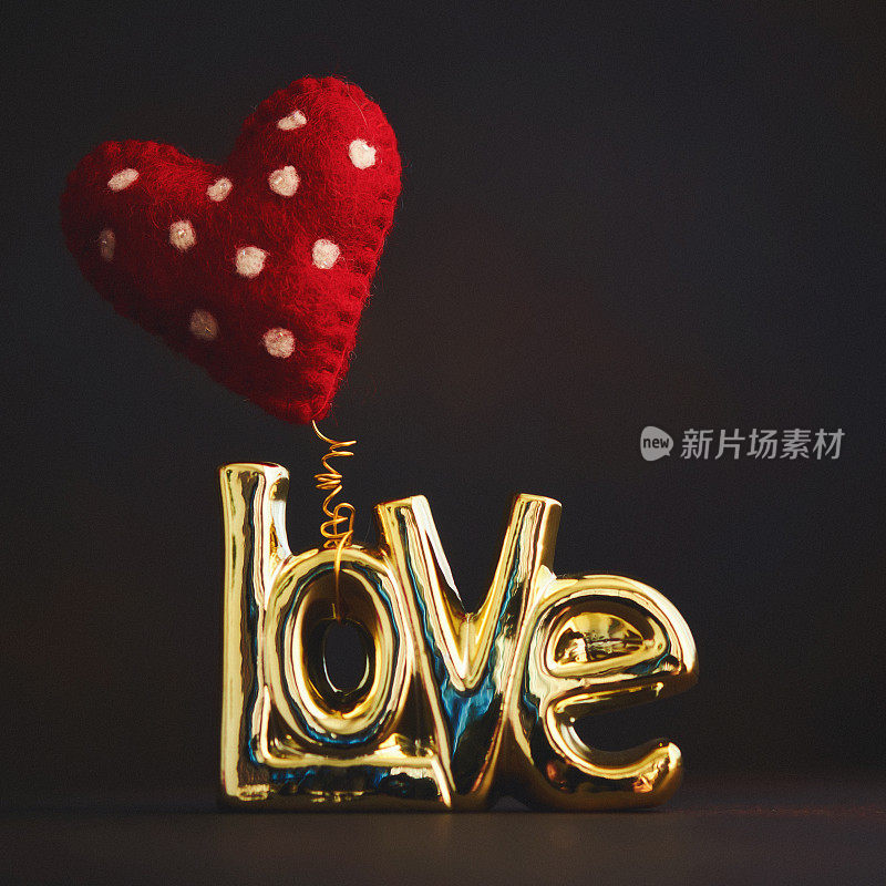 金色爱情标志与红色毡气球