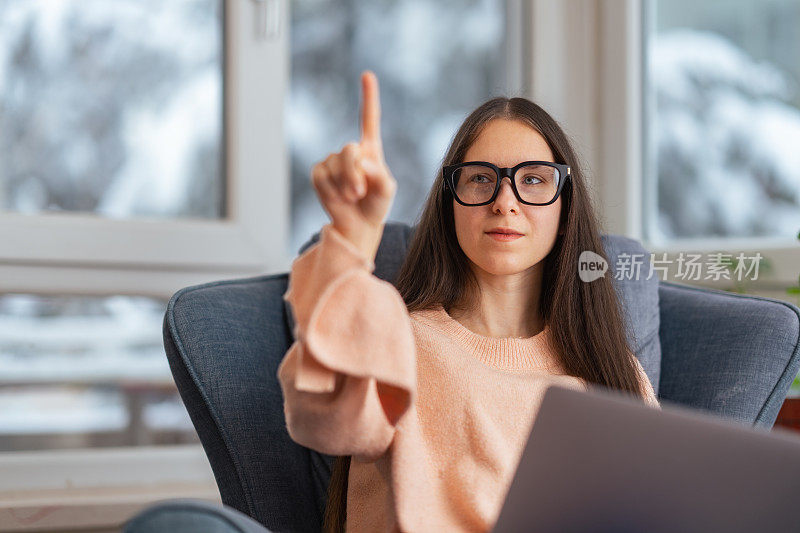 美丽的女商人坐在沙发上的肖像和使用智能眼镜。元境智能眼镜虚拟现实技术概念