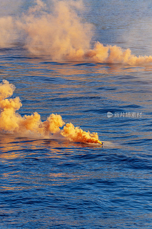蓝色海洋中的橙色烟雾弹。遇险信号