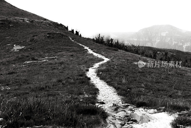 黑色和白色的路径在山上，背景与复制空间