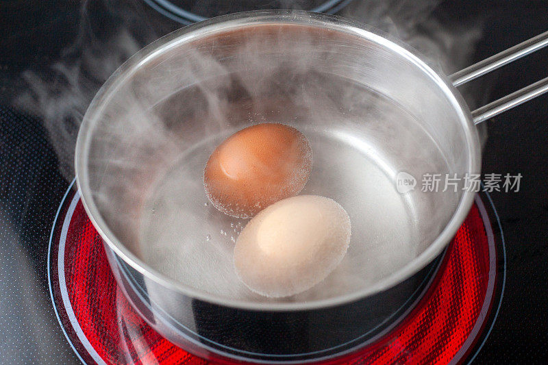 鸡蛋在电炉上的小铁锅里煮