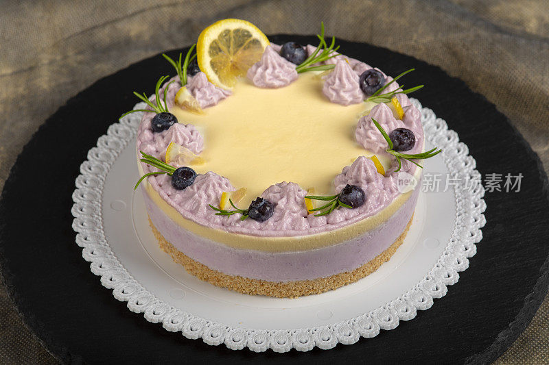 用生奶油和迷迭香装饰的自制蓝莓芝士蛋糕