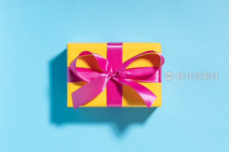 粉红色的礼品盒上有蓝色的黄丝带