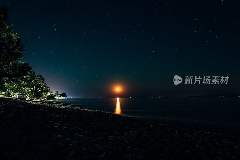 夜间灯塔在海水中的倒影