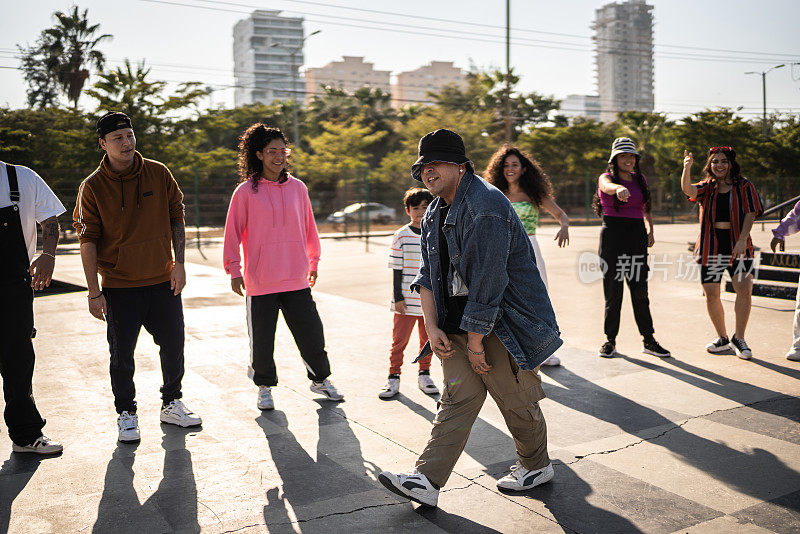 年轻男子霹雳舞在街头派对与她的朋友在户外