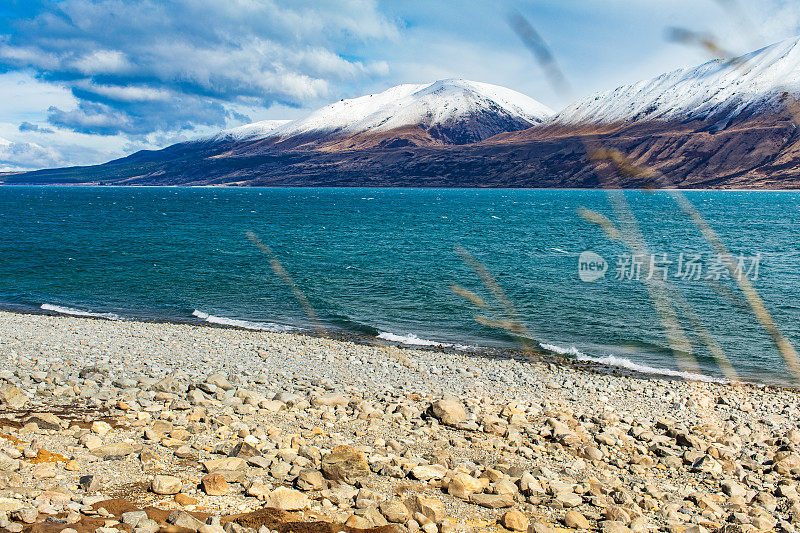 风吹过绿松石湖，背景是雪山的戏剧性景观