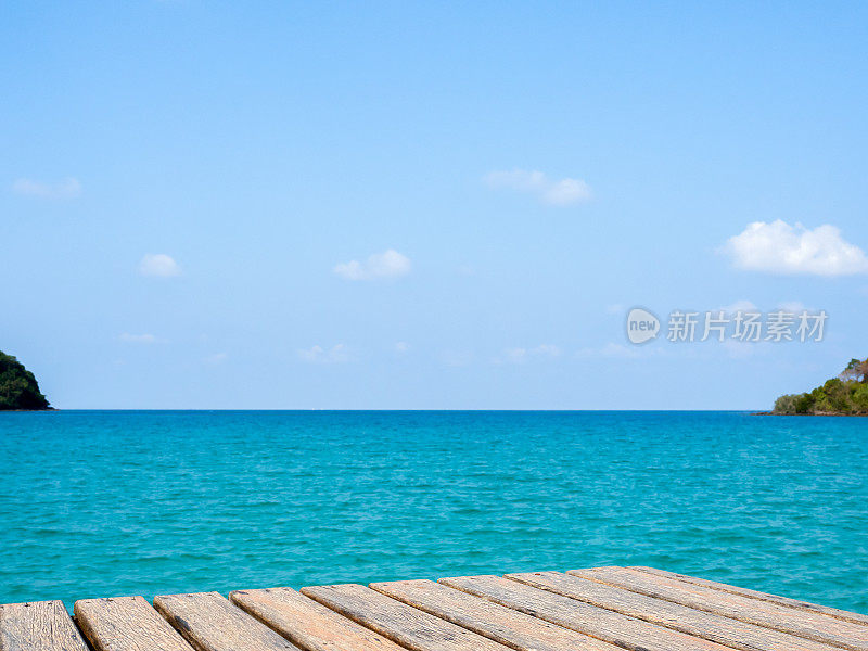 空的旧木桌模板上的热带开阔的大海和明确的夏季天空背景。棕色桌面或垃圾木板空间放置产品，包装夏季广告活动。