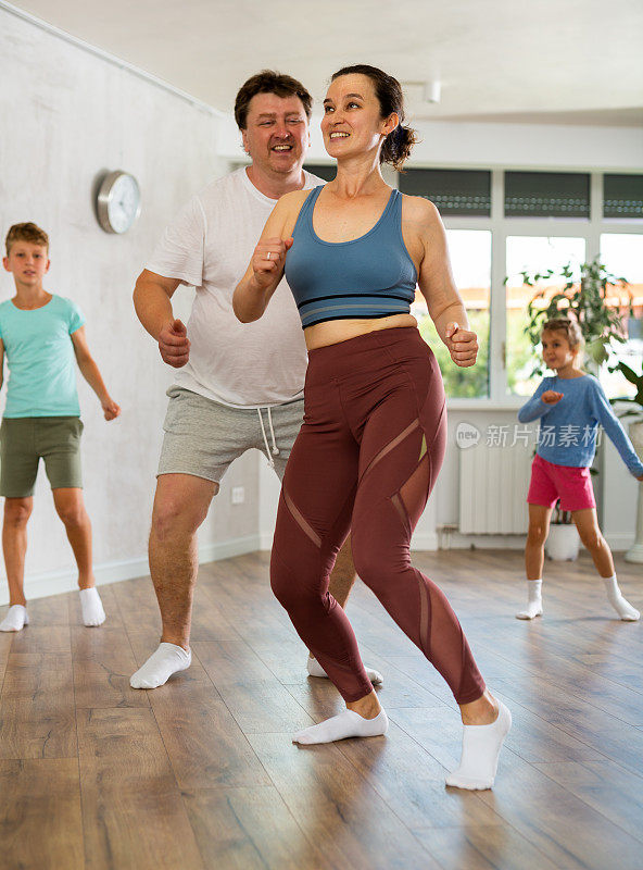 在家庭课上，妈妈和爸爸在舞蹈工作室成对地学习动感布吉舞