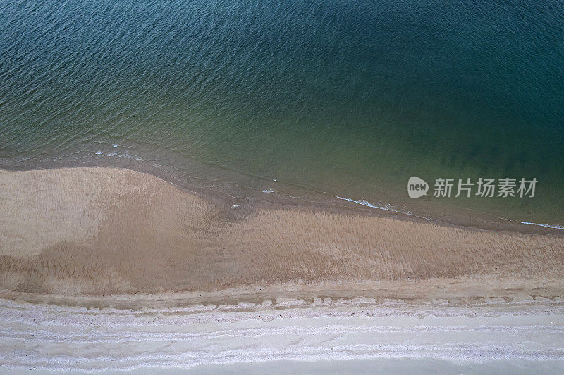 垂直鸟瞰干净的白色海滩和深蓝色的海水