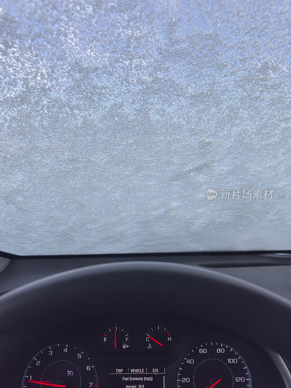 从冰雪覆盖的汽车挡风玻璃里看到的景象。
