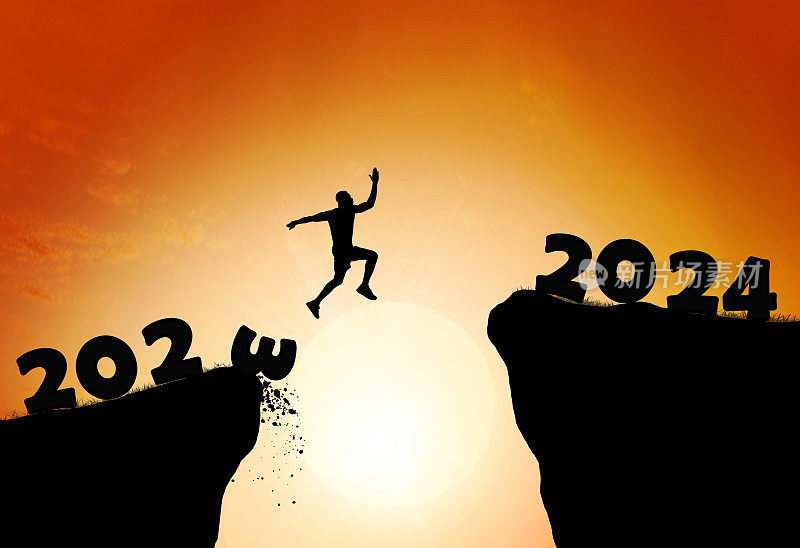 2024年新年快乐。从2023年到2024年云天背景上跳伞的男人剪影。