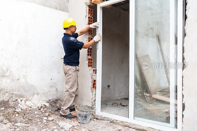 建筑工人在工地安装窗户