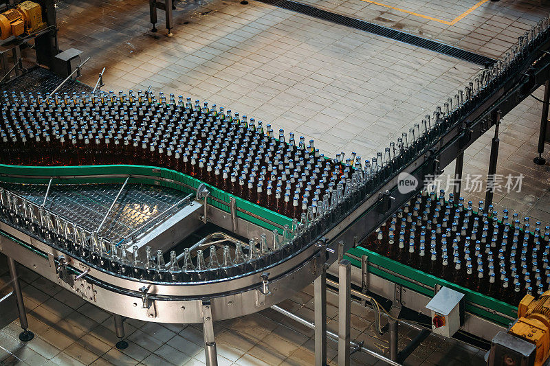 现代化自动化啤酒装瓶生产线。传送带上移动的啤酒瓶