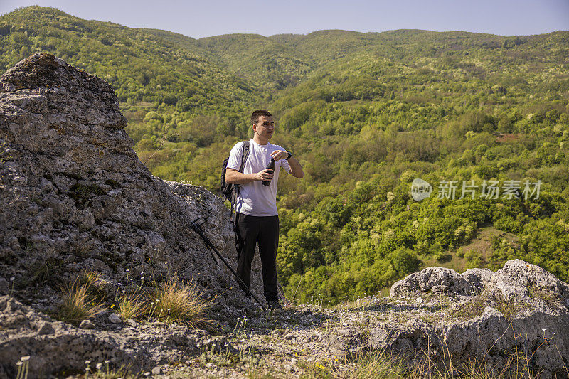 春天，小伙子们在山间徒步旅行后，正在喝水休息。