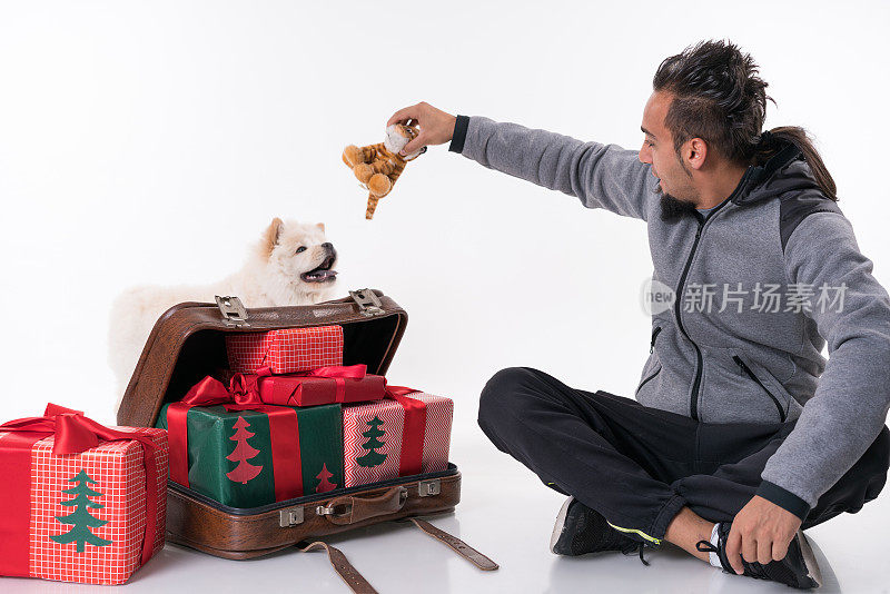 松狮犬小狗和带圣诞礼物的年轻人