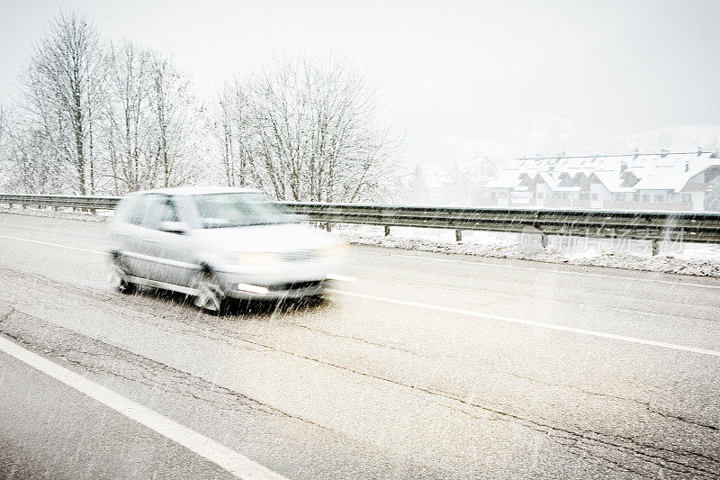在下雪时快速行驶的汽车