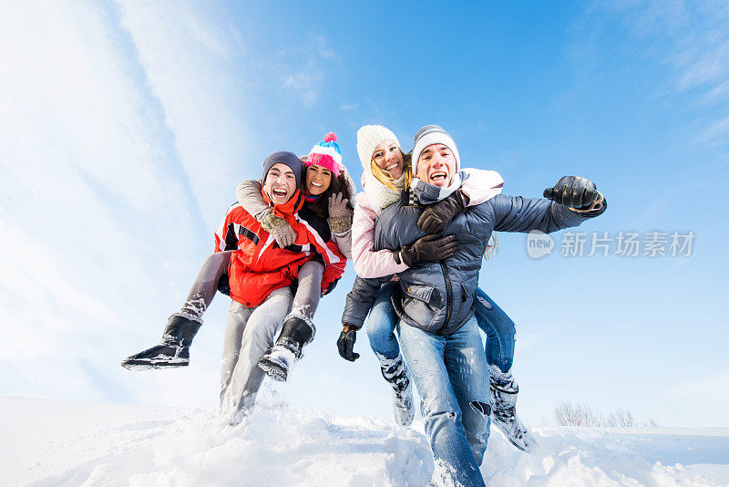 年轻夫妇在雪中嬉戏。