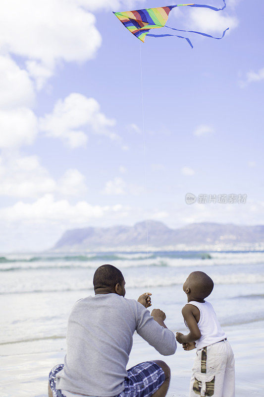 非洲父子在海滩上放风筝