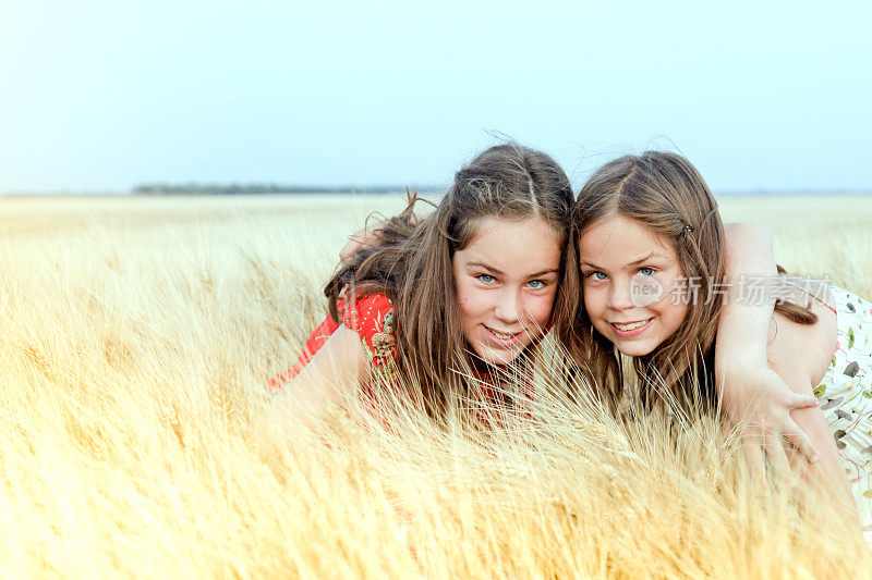 两个女孩在一片成熟的麦田里