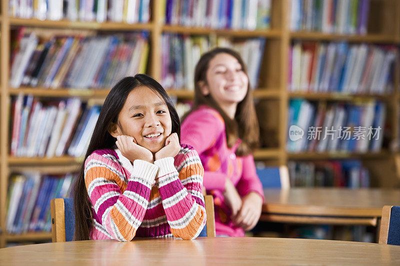 多种族女孩坐在学校图书馆里