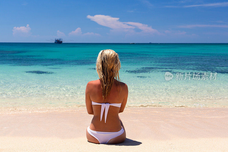 年轻女子坐在沙滩上