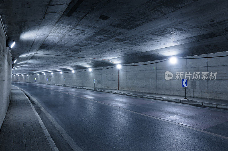 空无一人的高速公路进入了有灯光的隧道