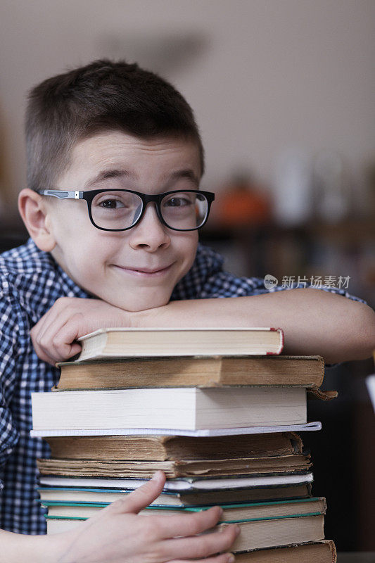 漂亮的男孩拿着书在做作业