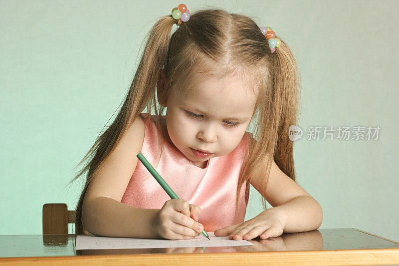 小女孩写字母表中的一个字母