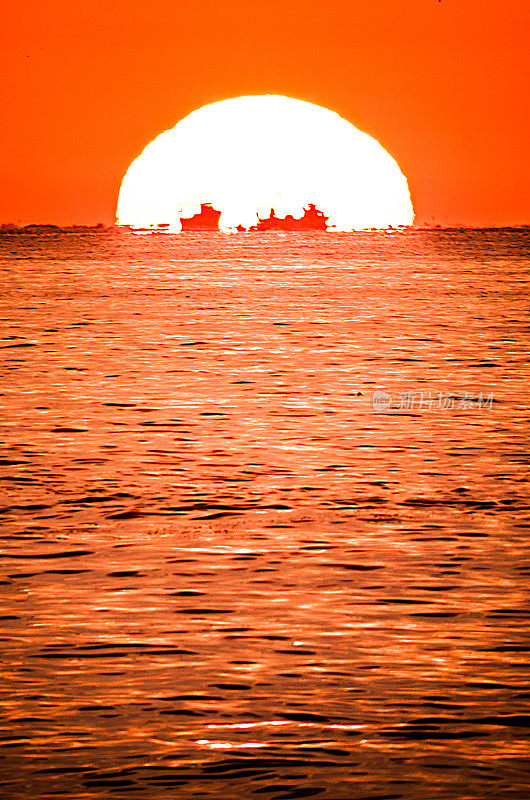 渔船前太阳日出日落变焦海橙色
