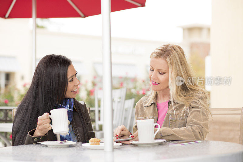 女性朋友在户外咖啡馆看数字平板电脑。