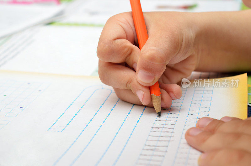 小男孩勤奋地用铅笔在笔记本上写字。幼儿教育与教育学。