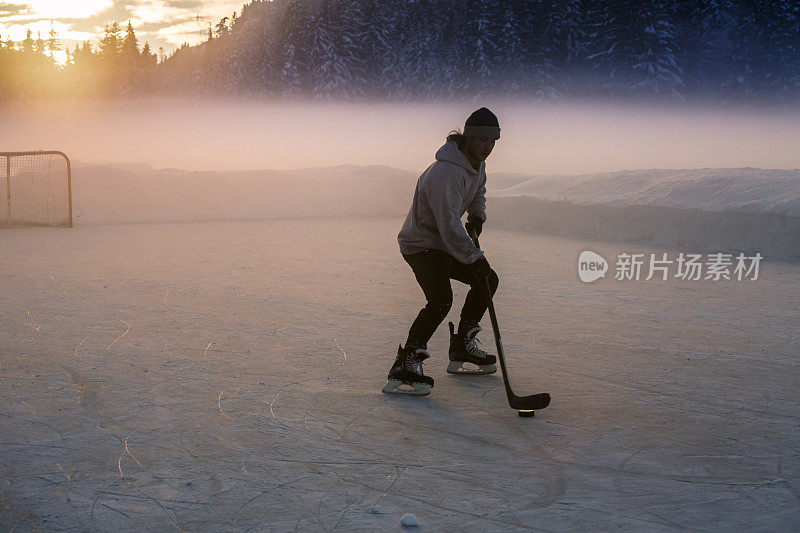 年轻人在结冰的湖面上打曲棍球。