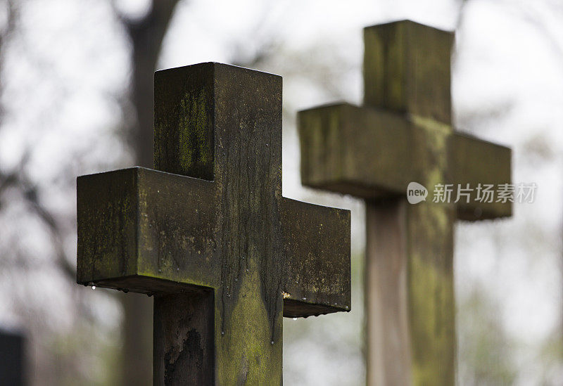 11月雨中墓园石十字架。