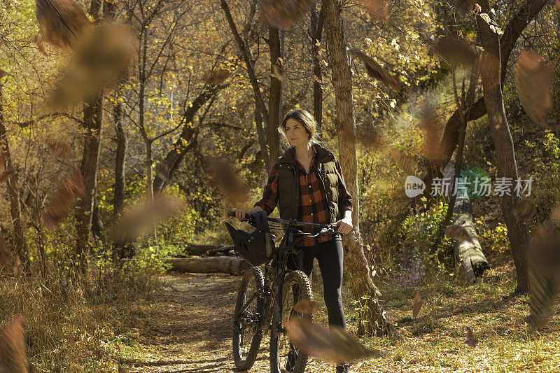 秋天，在森林里骑山地车下坡的女人