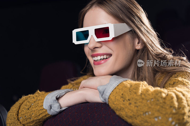 年轻女子戴着3d眼镜在电影院看电影