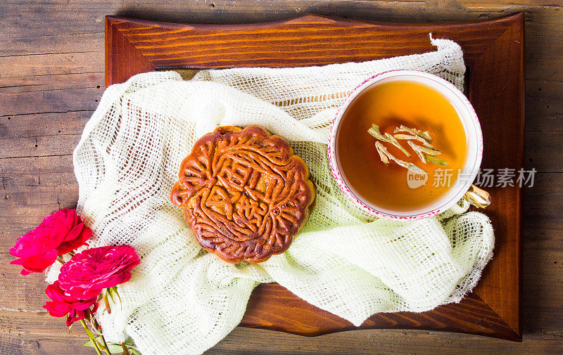 中国的月饼和玫瑰茶放在木碟上